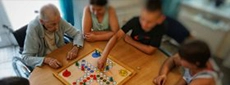 Schüler engagieren sich mit älteren Menschen beim Brettspiel