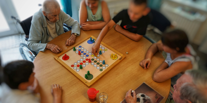 Schüler engagieren sich mit älteren Menschen beim Brettspiel